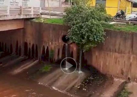 Homem usa galhos para descer c&oacute;rrego na Ernesto Geisel e sai correndo pelo canal