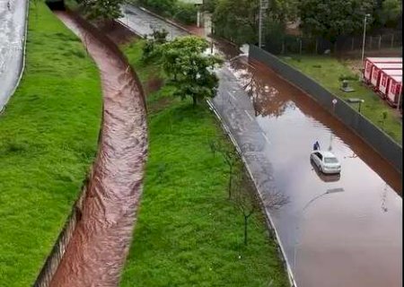 Carro fica ilhado em rotat&oacute;ria alagada ap&oacute;s temporal na cidade