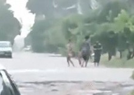 Crian&ccedil;as brincam na chuva que causa enxurrada em ruas sem asfalto